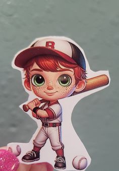 a person holding up a sticker with a baseball player on it's face