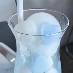 a glass filled with ice and water on top of a table