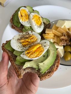 an open face sandwich with avocado, hard boiled eggs and cheese on it