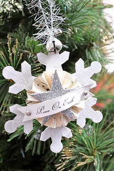 a snowflake ornament hanging from a christmas tree with a ribbon on it