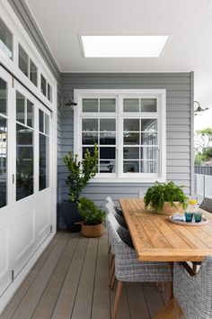 a wooden table sitting on top of a wooden floor next to a white door and window