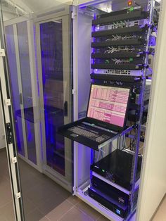 a laptop computer sitting on top of a shelf in a room with other equipment around it