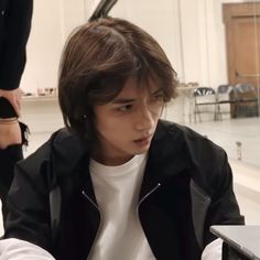 a young man sitting in front of a laptop computer