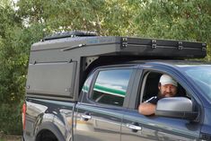 a man sitting in the drivers seat of a pick up truck looking out the window