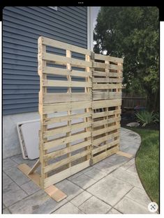 a wooden fence made out of pallets on the side of a house