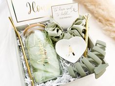 an open box with some items in it on a white table cloth and gold foil