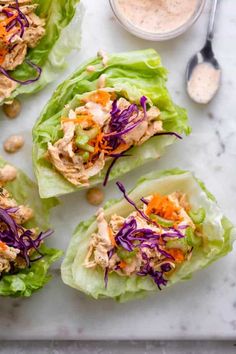 four lettuce wraps filled with chicken salad and garnished with red cabbage