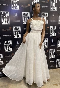 a mannequin wearing a white dress on display