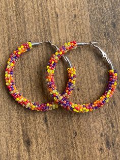 A pair of hoop earrings made with limited edition seed beads in beautiful sunset colors! 30mm (1 inch) 40mm (1.5 inch) 50mm (2 inch) These are made from a VERY limited mix so get them while you can! These one of a kind earrings are fantastic for raves, night clubs, parties, summer vacations, festivals or just for a pop of color in your wardrobe.  Made with a spring clasp for ease. Hypoallergenic professional grade metals, none of the cheap stuff used here! Want another size or have something els Rainbow Beaded Hoop Earrings For Festivals, Bohemian Beaded Rainbow Hoop Earrings, Festival Multicolor Beaded Hoop Earrings, Rainbow Round Hoop Earrings With Colorful Beads, Unique Multicolor Beaded Hoop Earrings, Cheap Stuff, Night Clubs, Boho Hoop Earrings, Summer Vacations