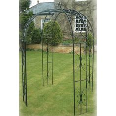 an iron garden arbor in the middle of a lawn