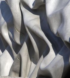 a close up view of the wavy white marble material on this building's facade