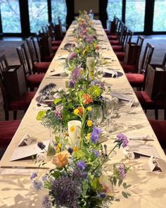 a long table is set with flowers and candles for an elegant dinner or party event