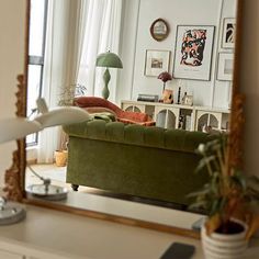 a living room filled with furniture and a large mirror over the top of a dresser