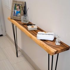 a long wooden table with some items on it and a picture frame next to it