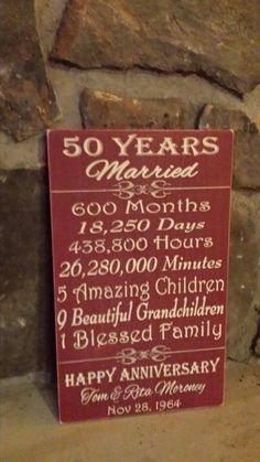 a sign that is on the side of a stone wall in front of a brick wall