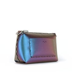 "Small crossbody bag with a zipper top to securely hold your stuff, thoughtfully crafted from super-soft and easily cleanable iridescent blue vegan leather. This handbag features an interior and exterior pocket (each sized to fit a large phone) and shoulder/crossbody strap that adjusts from to 37\" to 66\" (94 - 168 cm) to fit all body types. All Mohop handbags are handmade in our workshop in northern Illinois from animal-friendly materials and American-made hardware. 100% Vegan! Measurements: H Modern Purple Leather Shoulder Bag, Purple Leather Shoulder Bag With Zipper Closure, Blue Crossbody Flap Bag With Gold-tone Hardware, Shoulder Bag Designer, Blue Crossbody Bag With Gold-tone Hardware, Purple Leather-handled Crossbody Bag, Iridescent Blue, Designer Handbag, Zipper Top