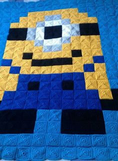 a blue and yellow quilted blanket with an image of a cartoon character on it