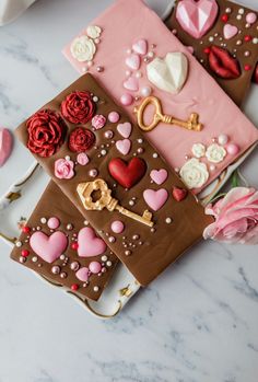 two valentine's day cookies on a plate with pink roses and chocolate icing