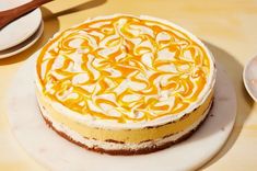 there is a cake that has been decorated with orange swirls on it and sits on the table