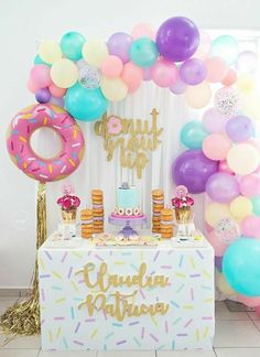 a birthday party with balloons, cake and donuts