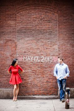 a man and woman standing in front of a brick wall with the word may 2012 written on it