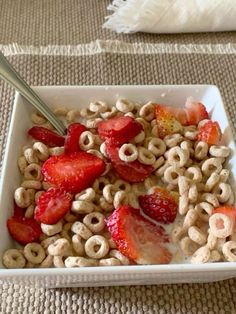 a white bowl filled with cereal and strawberries