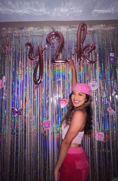 a woman standing in front of balloons and streamers with the number twenty nine on it