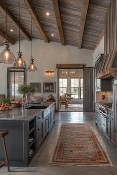 a kitchen with an area rug on the floor and lights hanging from the ceiling above it