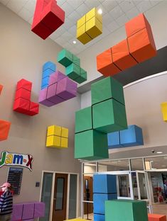 the colorful cubes are hanging from the ceiling in the building's lobby area