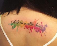 the back of a woman's shoulder with colorful paint splattered on it