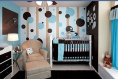 a baby's room decorated in blue, brown and white with polka dot wallpaper