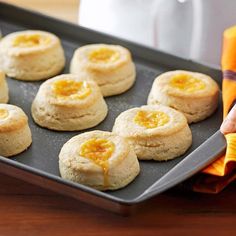 a pan filled with cookies sitting on top of a wooden table next to an orange napkin