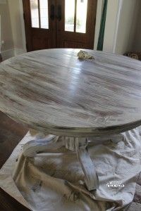 a round wooden table is being prepared for the paint job on it's base