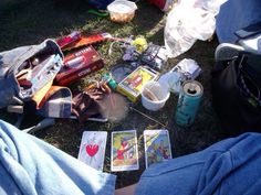 some cards are laying on the ground next to someone's feet and backpacks