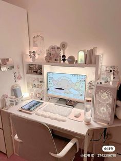 a white desk with a computer on it and lots of other items in the room