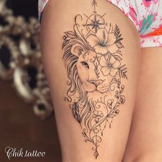 a woman's thigh with a lion and flowers tattoo design on the side of her leg