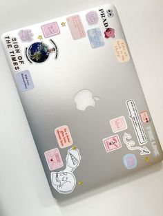 an apple laptop with stickers on it