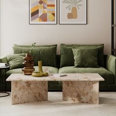 a living room with green couches and paintings on the wall