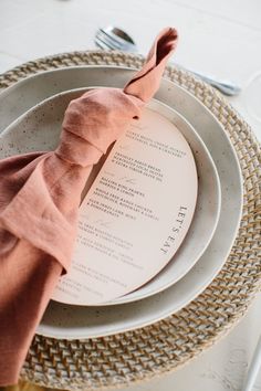 a place setting with napkins and silverware on a white tableclothed plate