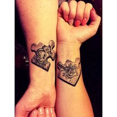 two people with matching tattoos on their arms holding up puzzle pieces that look like hearts