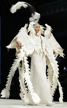 a man dressed in white with feathers on his head