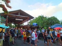 a group of people standing in line at an outdoor market