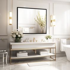 a white bathroom with gold accents and marble flooring, along with a large mirror over the bathtub