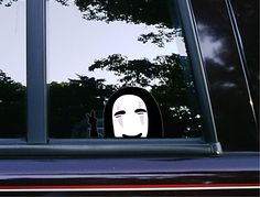 a woman's face is seen through the window of a car with trees in the background