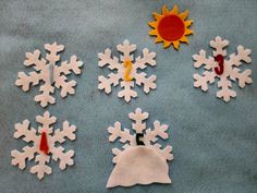 paper snowflakes are laid out on a blue surface with red and yellow pins