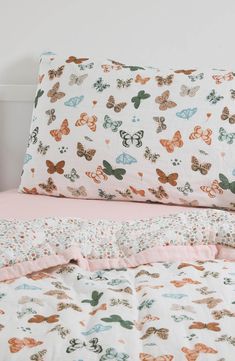 an unmade bed with butterflies on it