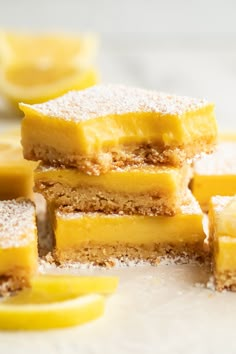 three pieces of lemon bars stacked on top of each other with powdered sugar on them