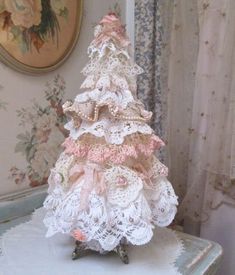 a small crocheted christmas tree sitting on top of a table next to a window