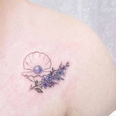 a woman's shoulder with a flower tattoo on the left side of her breast