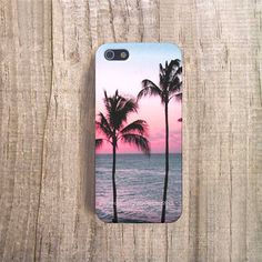 a phone case with two palm trees in front of a sunset on the ocean and pink sky